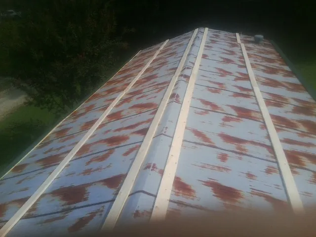 Rusted metal roof panels with new wood purlins before replacement — Storm Damage Roof Repair in Seligman by Roofing Brothers