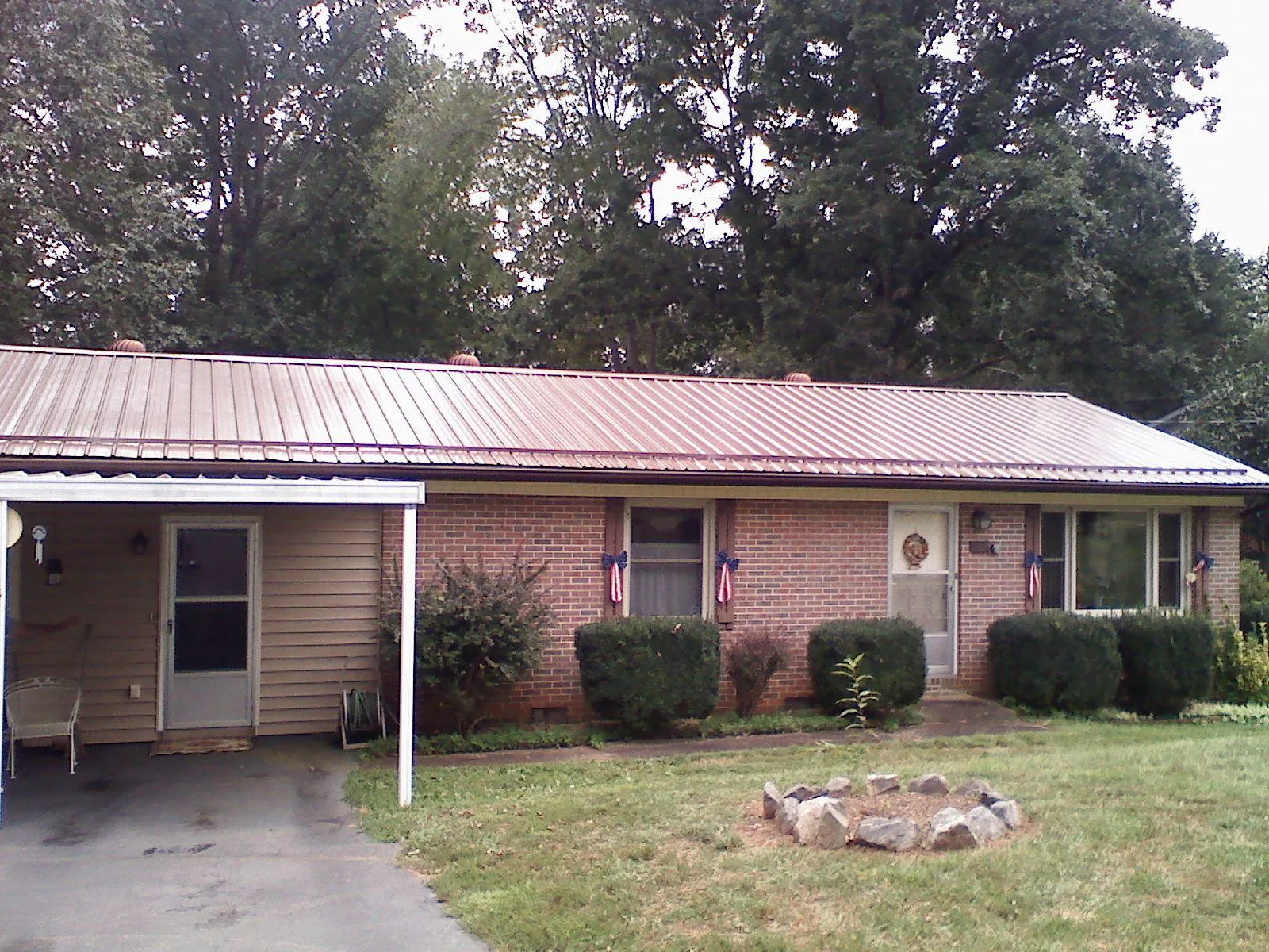 Bronze metal roof and carport on a brick ranch home — Roof Repair work by our crew in Seligman